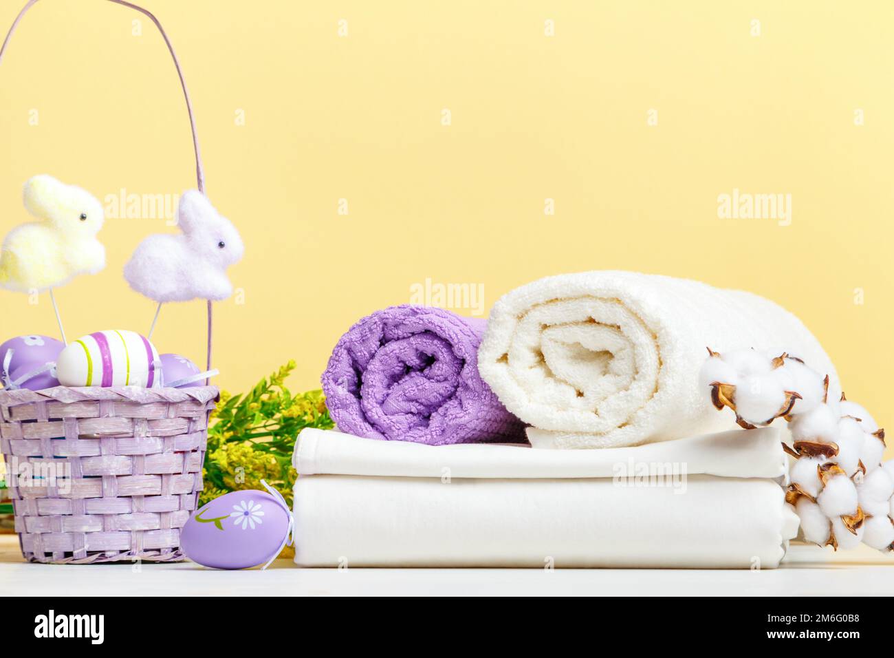 Handtuchrollen weiße Bettwäsche mit Osterdekor auf dem Tisch. Stillleben Stockfoto