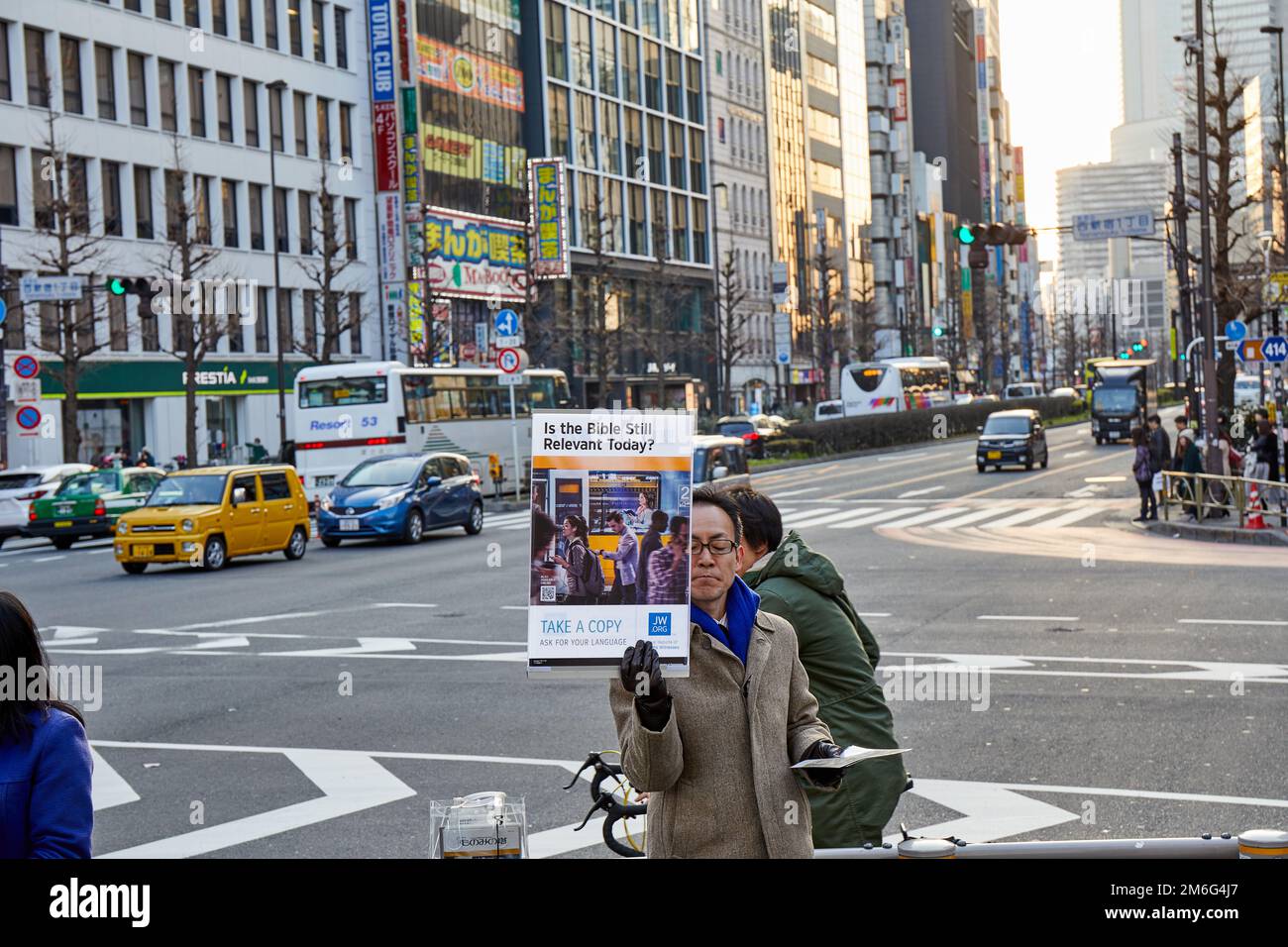 Ist die Bibel heute noch relevant? - Jehovas Zeuge hält das Schild hoch; Shinjuku, Tokio, Japan Stockfoto