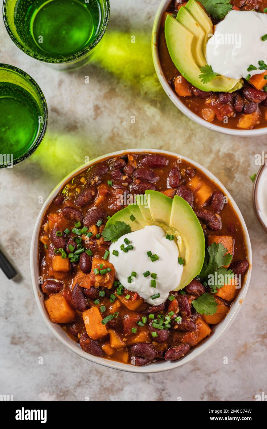Chili Süßkartoffeln und schwarze Bohnen mit Tomaten, Sellerie in einer Pfanne auf dem Tisch. Horizontale Draufsicht von oben Stockfoto