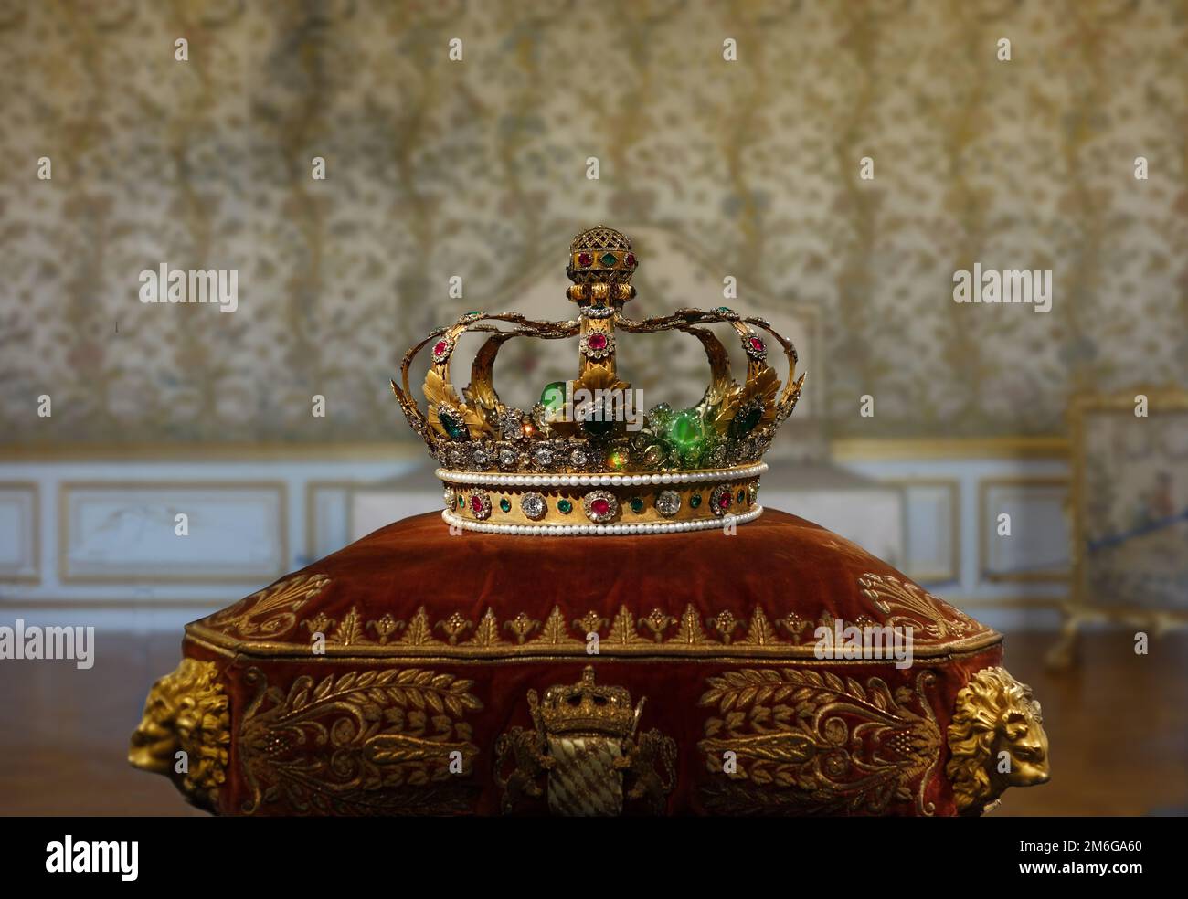 Goldene Krone mit Juwelen und Edelsteinen auf einem königlichen zeremoniellen Kissen Stockfoto