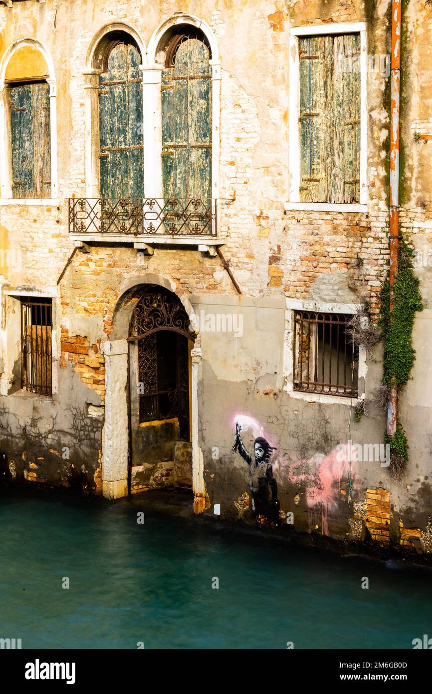 VENEDIG, ITALIEN - 26. NOVEMBER 2022: Venedig Kanalgewässer, Tor und Graffiti von Banksy mit langer Exposition im Winter 2022 Stockfoto