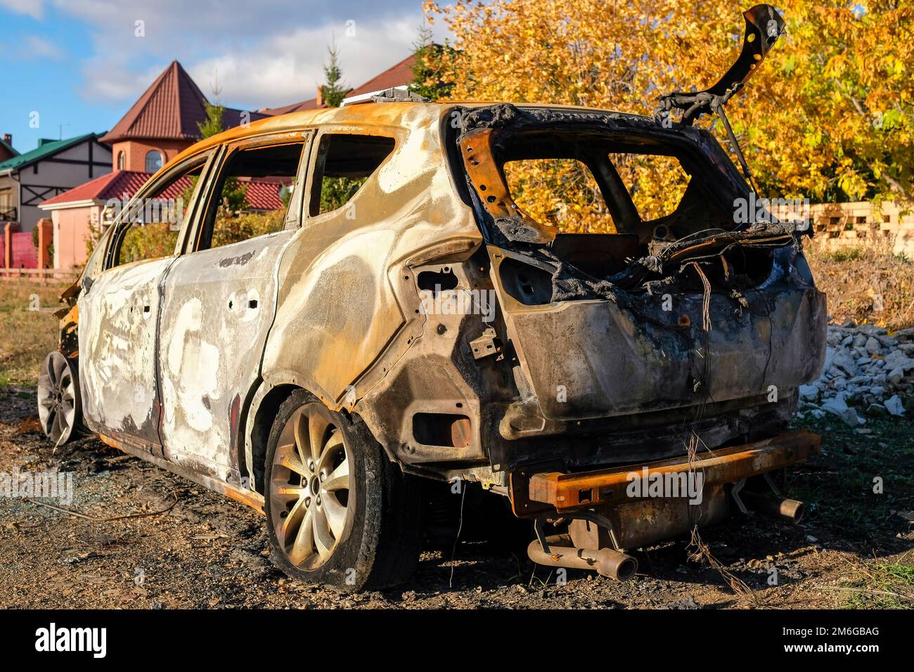 Ein ausgebranntes Auto steht im Herbst auf der Straße Stockfoto