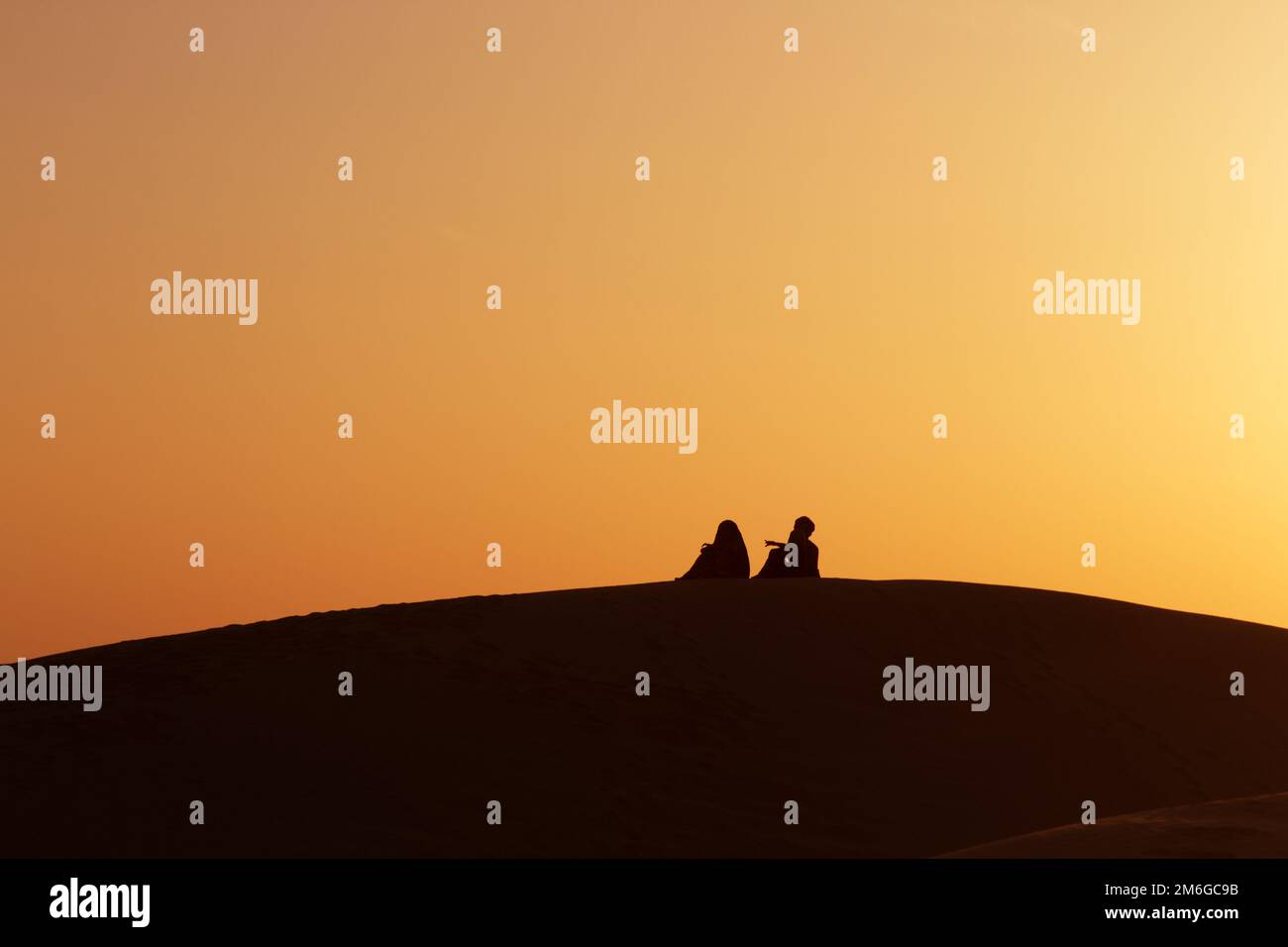 Wüstennomaden auf dem Wappen eines Barchans bei Sonnenuntergang Stockfoto