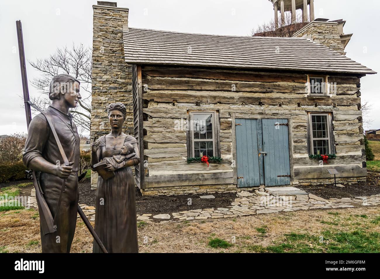 Monument Park in Hamilton, Ohio, mit einer Pionierstatue vor einer historischen Hütte. Stockfoto