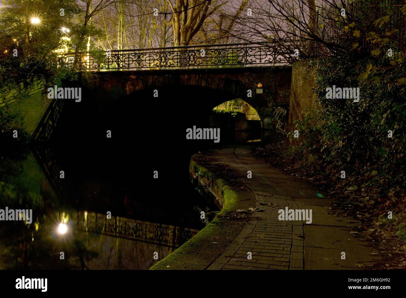 Blick auf einen Fußweg unter einer Brücke am Regent's Canal bei Nacht in North London, Camden Stockfoto