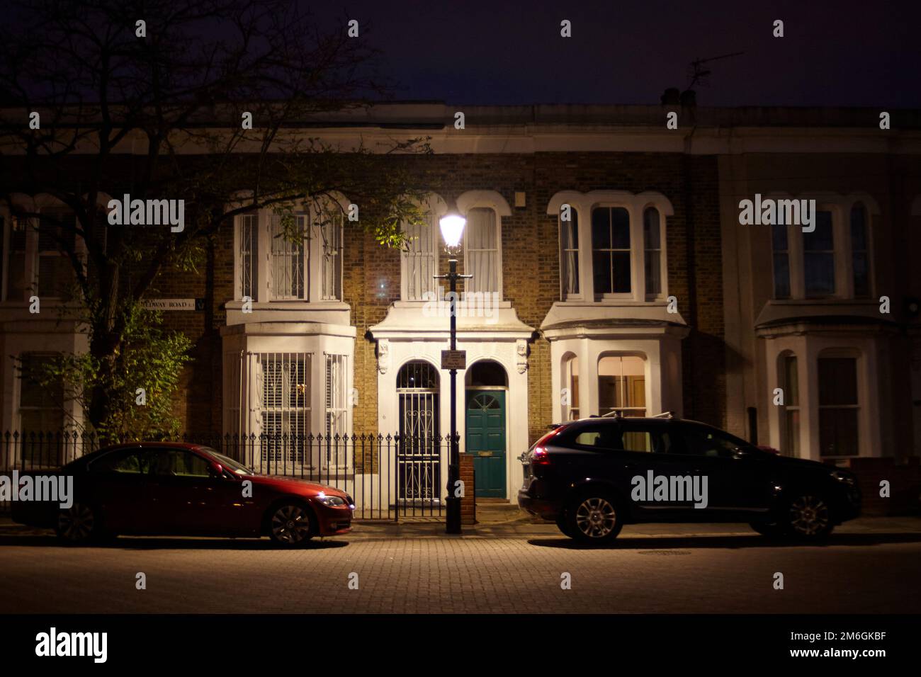 Eine dunkle, bedrohliche Londoner Tür bei Nacht, beleuchtet von einer einzelnen Straßenbeleuchtung Stockfoto