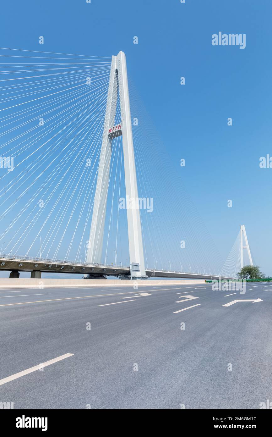 Leere Asphaltstraße und Brückenhintergrund mit Kabelbrücken Stockfoto