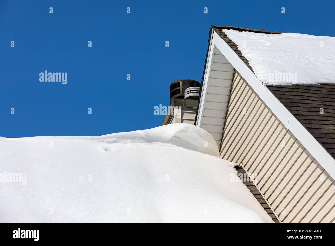Schneeverwehung auf dem Dach des Hauses nach Wintersturm. Dachschäden, Schneeräumung, Hausinstandhaltung und Reparaturkonzept. Stockfoto