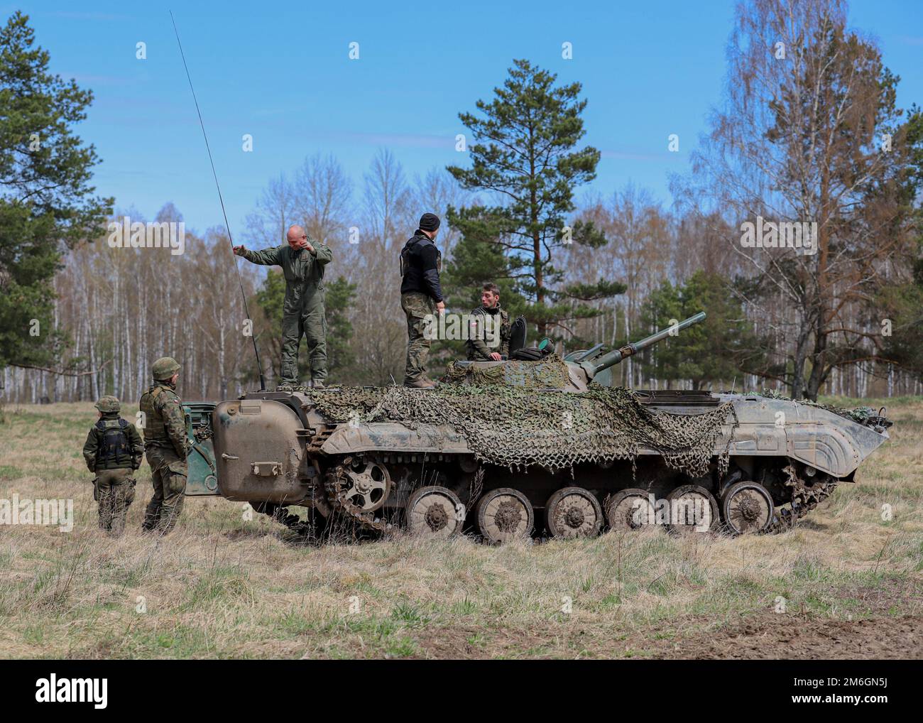 Bemowo Piskie Training Area, Orzysz, Polen - Polnische Soldaten ein Teil der mechanisierten Infanterie-Brigade aus dem Jahr 15. spricht mit Soldaten der polnischen Territorialen Verteidigungskräfte, nachdem sie während des letzten Trainingstags der Übung einen mechanisierten Panzer betrieben hatten Thunderbolt Focus 2022, April 27. Polnische Soldaten unter anderem aus alliierten Nationen arbeiteten in dynamischen Teams gegen Taktiken, Techniken und Verfahren, die von feindlichen Kräften eingesetzt wurden, zusammen und ermöglichten es den Gefechtsverbänden, alle Kriegskämpfe, Interoperabilität und Kontrollfähigkeiten zu üben, zu verfeinern und zu validieren. Stockfoto