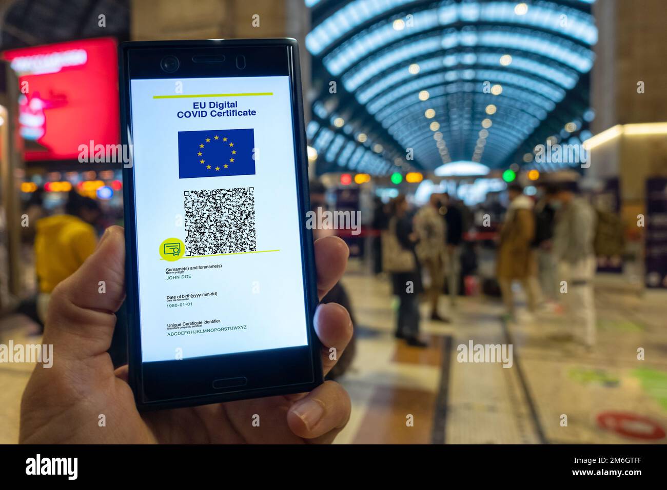 Frau zeigt auf dem Smartphone das EU Digital Covid Zertifikat. Stockfoto