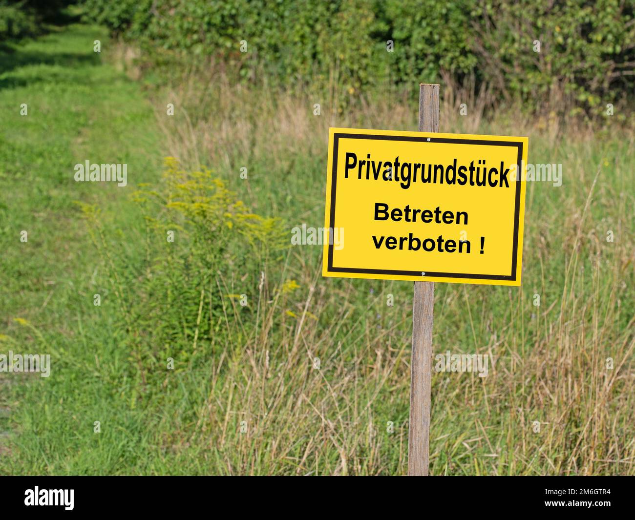 Schild mit dem Aufdruck 'Privatgrundstück, Betreten verboten', Übersetzung 'Privatgrundstück, Eintritt verboten' Stockfoto