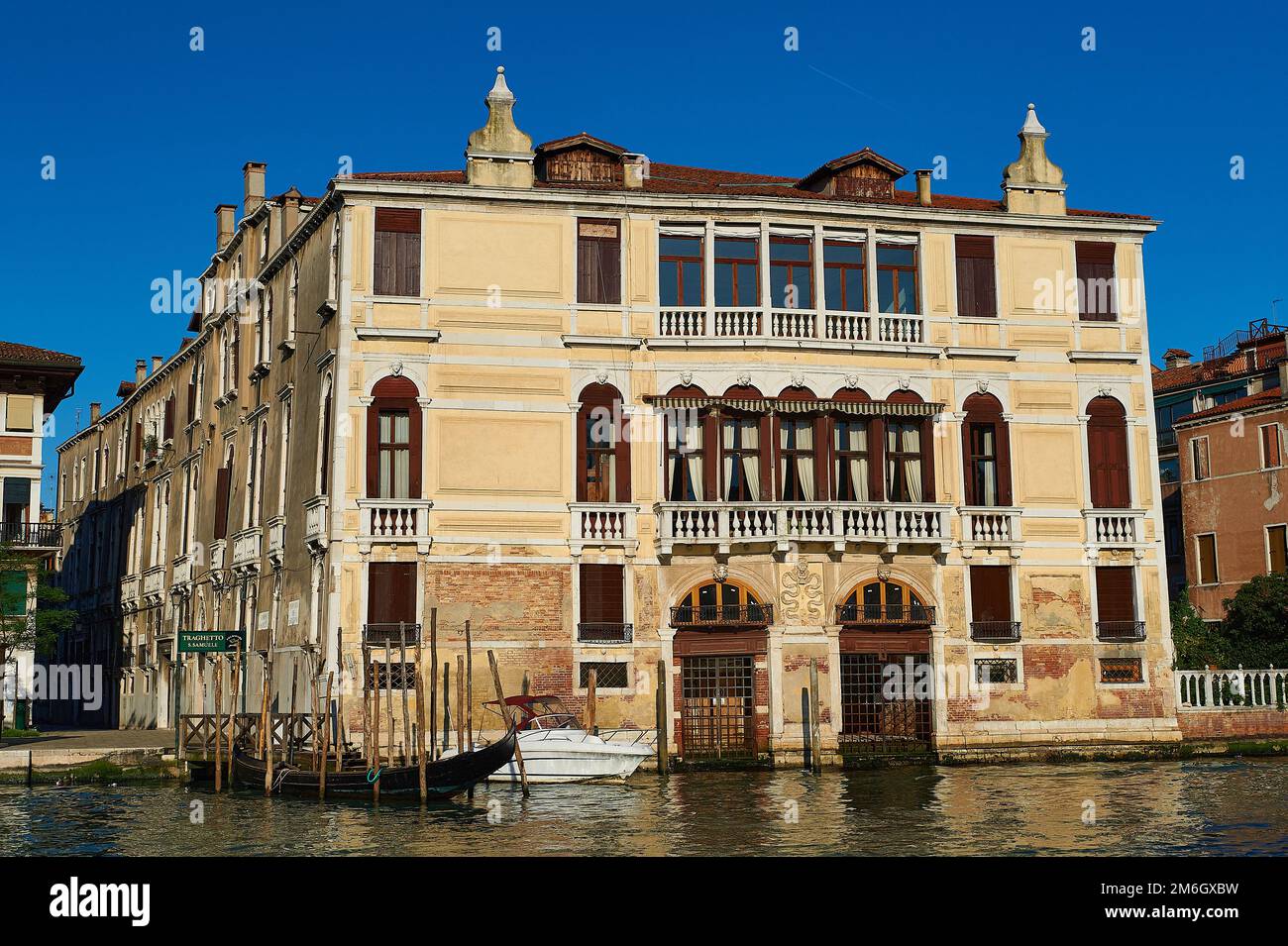 Blick auf eine typisch venezianische Fassade mit durch Wasser beschädigter Fassade und Holzpier für kleine Boote Stockfoto