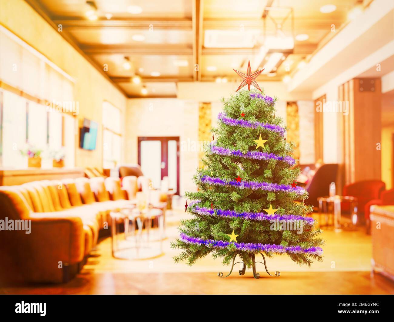 Ein künstlicher Weihnachtsbaum mit Lametta und Sternen steht auf einem unscharfen Hintergrund des Flurs mit einem großen Sofa. Helles Foto, Stockfoto