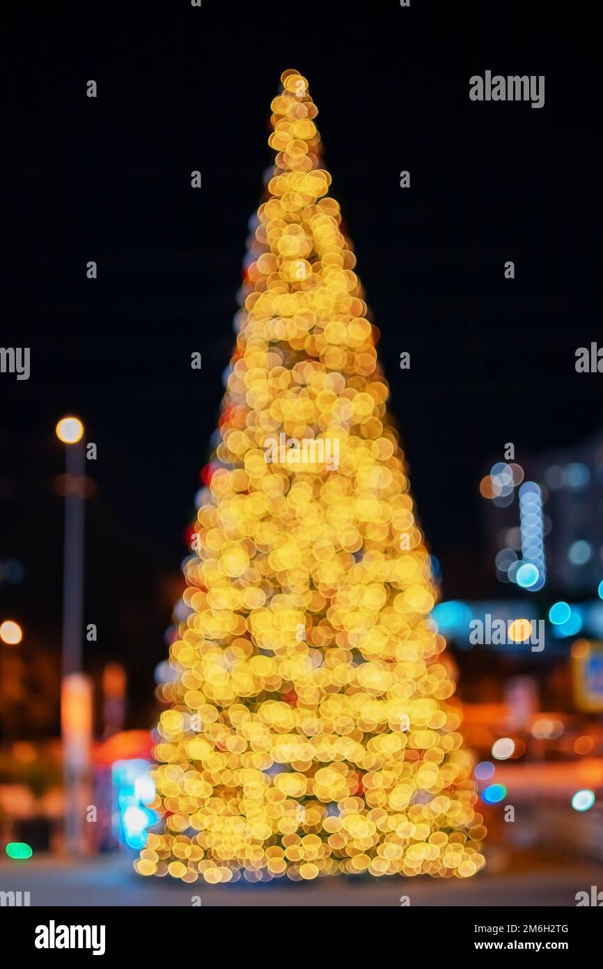 Großer Weihnachtsbaum in der Nachtstadt. Unschärfe-Effekte mit Bokeh-Effekt. Hintergrund verschwommenes Bild Stockfoto