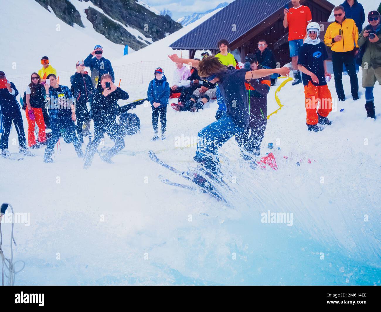 Russland, Sotschi 11.05.2019. Ein junger Mann mit Maske und Skiern springt mit Wasser aus dem Pool und macht eine coole Finte, Spritzer fliegen rein Stockfoto