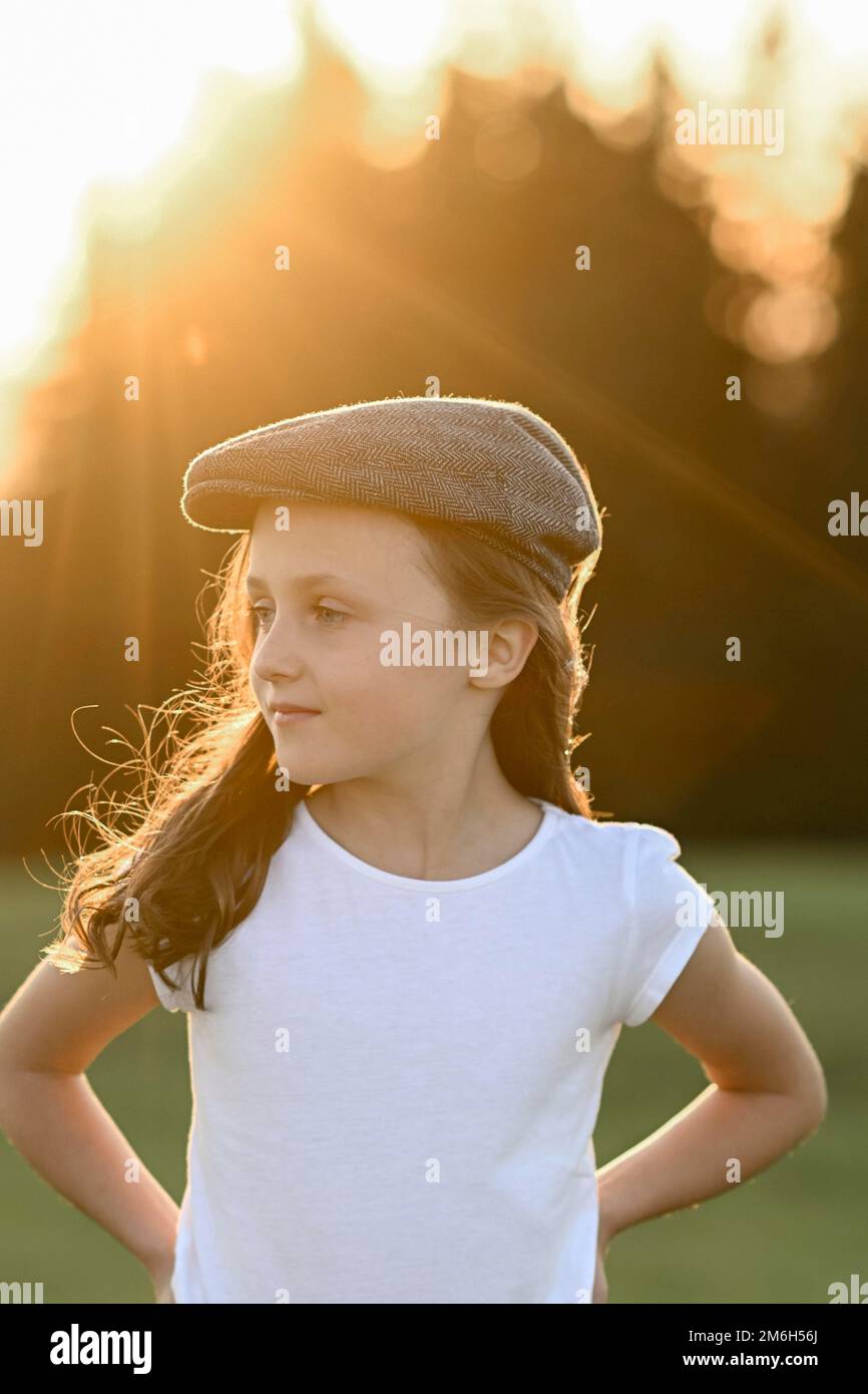 Mädchen, 8 Jahre, bei Sonnenuntergang auf einer Wiese Stockfoto