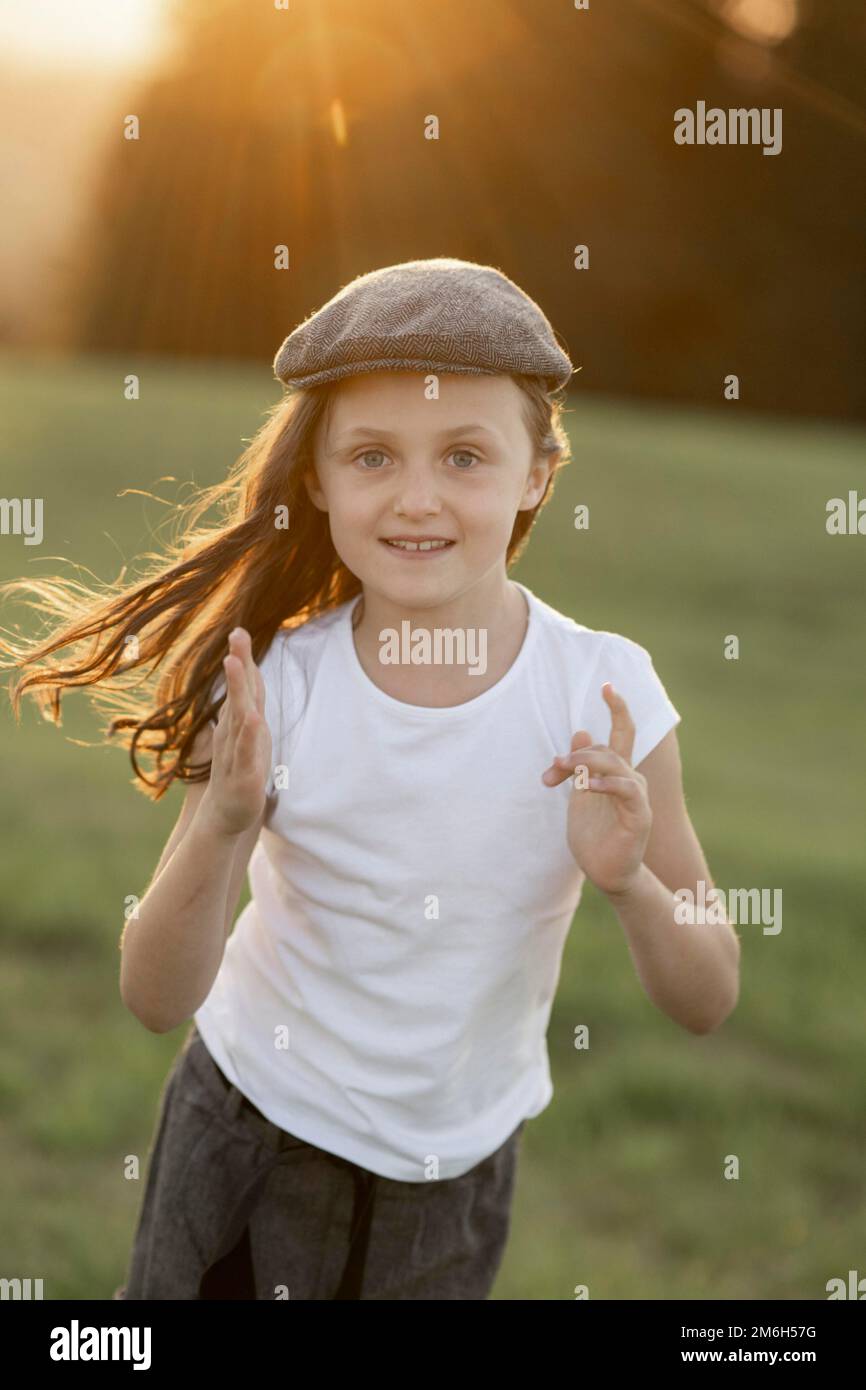 Mädchen, 8 Jahre, bei Sonnenuntergang auf einer Wiese Stockfoto