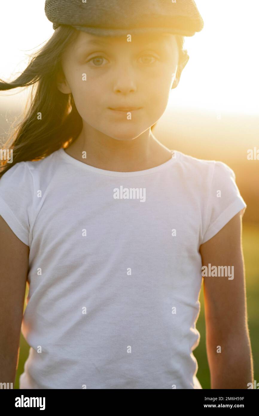 Mädchen, 8 Jahre, mit Mütze bei Sonnenuntergang Stockfoto