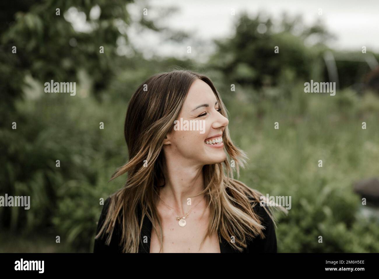 Lachende junge Frau im Porträt, 25, mit fliegenden Haaren Stockfoto