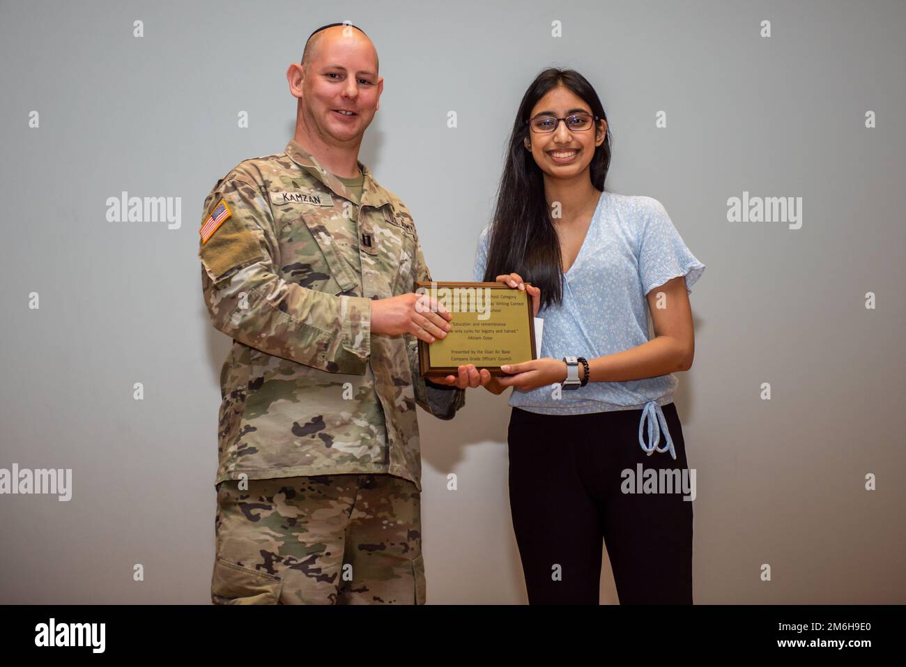 USA Army CPT Daniel Kamzan, Kaplan des 23d. Chemischen, biologischen, radiologischen und nuklearen Bataillons im Camp Humphreys, überreicht Ari Ramdatt, Schülerin der Osan Middle High School, mit einem Preis für den Schreibwettbewerb zum Holocaust Rememberance Day am 28. April 2022 auf dem Luftwaffenstützpunkt Osan, Republik Korea. Ihr Aufsatz über das Nachdenken über die tragischen Ereignisse des Holocaust und das Eintreten für das Recht wurde vom Rat der leitenden Angestellten des Unternehmens Osan ausgewählt und erhielt die Auszeichnung für die beste schriftliche Arbeit. Stockfoto