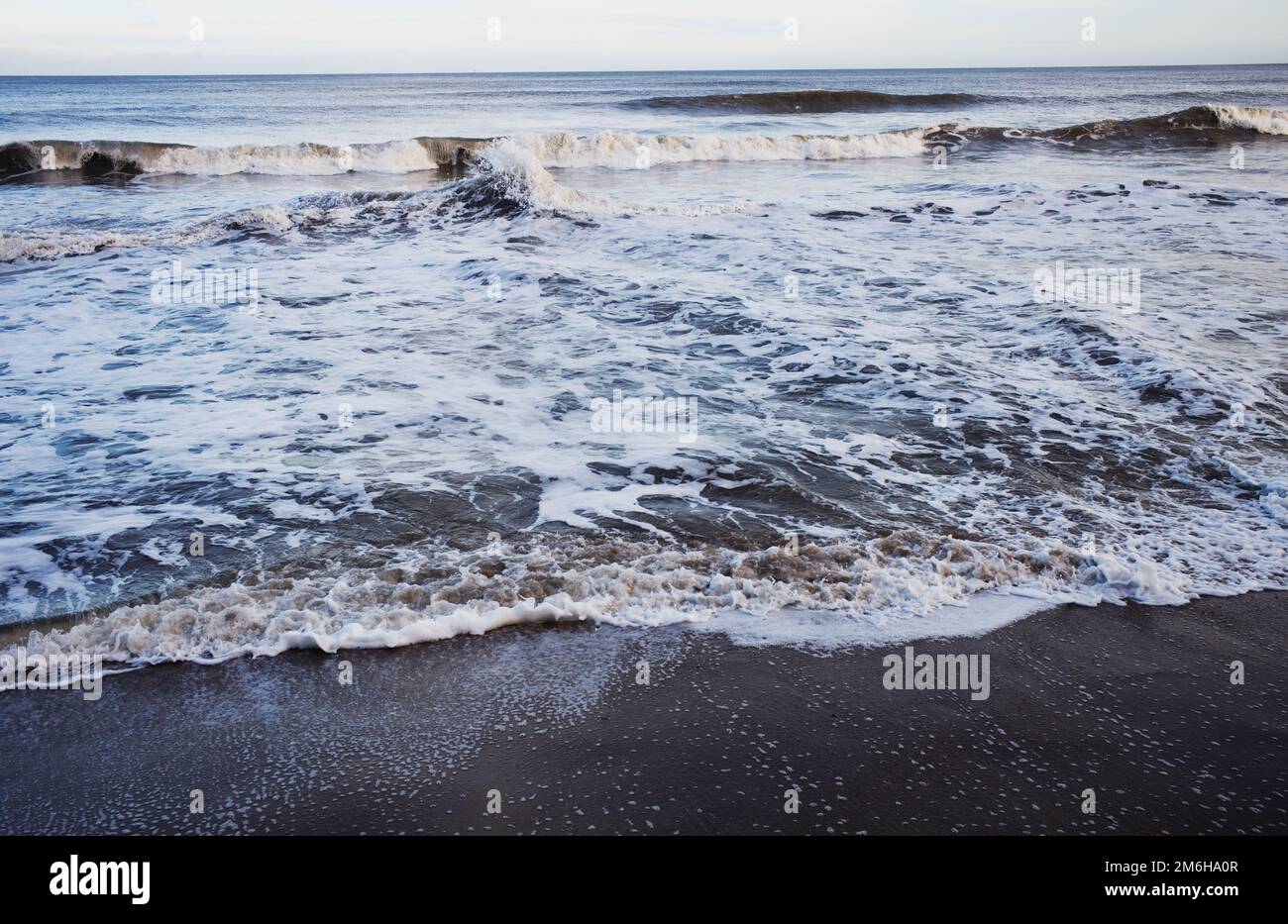 Wellen und Schaum brechen am Ufer Stockfoto