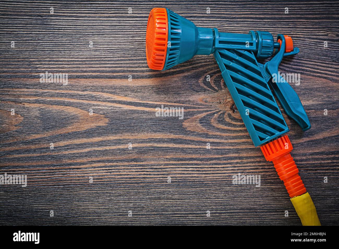 Wassersprinkler-Gummischlauch auf Holzbrettern, Landwirtschaftskonzept. Stockfoto