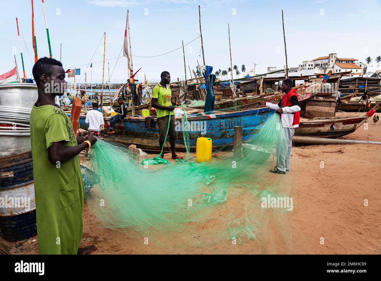 Fischer, die Netze reparieren, Fischerboote, Pirogen, Strand, Elmina, Golf von Guinea, Ghana Stockfoto