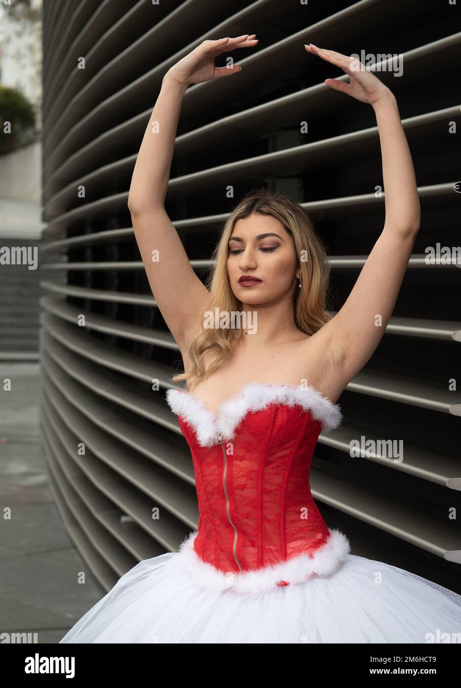 Ballerina trägt weißes und rotes weihnachtsballettkleid, das im Freien tanzt Stockfoto