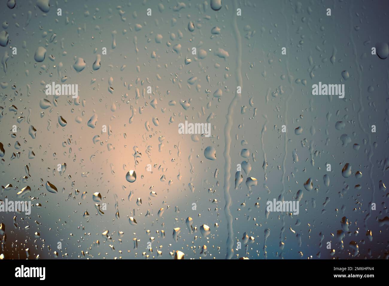 Wassertropfen auf die Scheibe, Glas. Die Lichter der Stadt. Bokeh - abstrakter, farbenfroher Hintergrund. Stockfoto