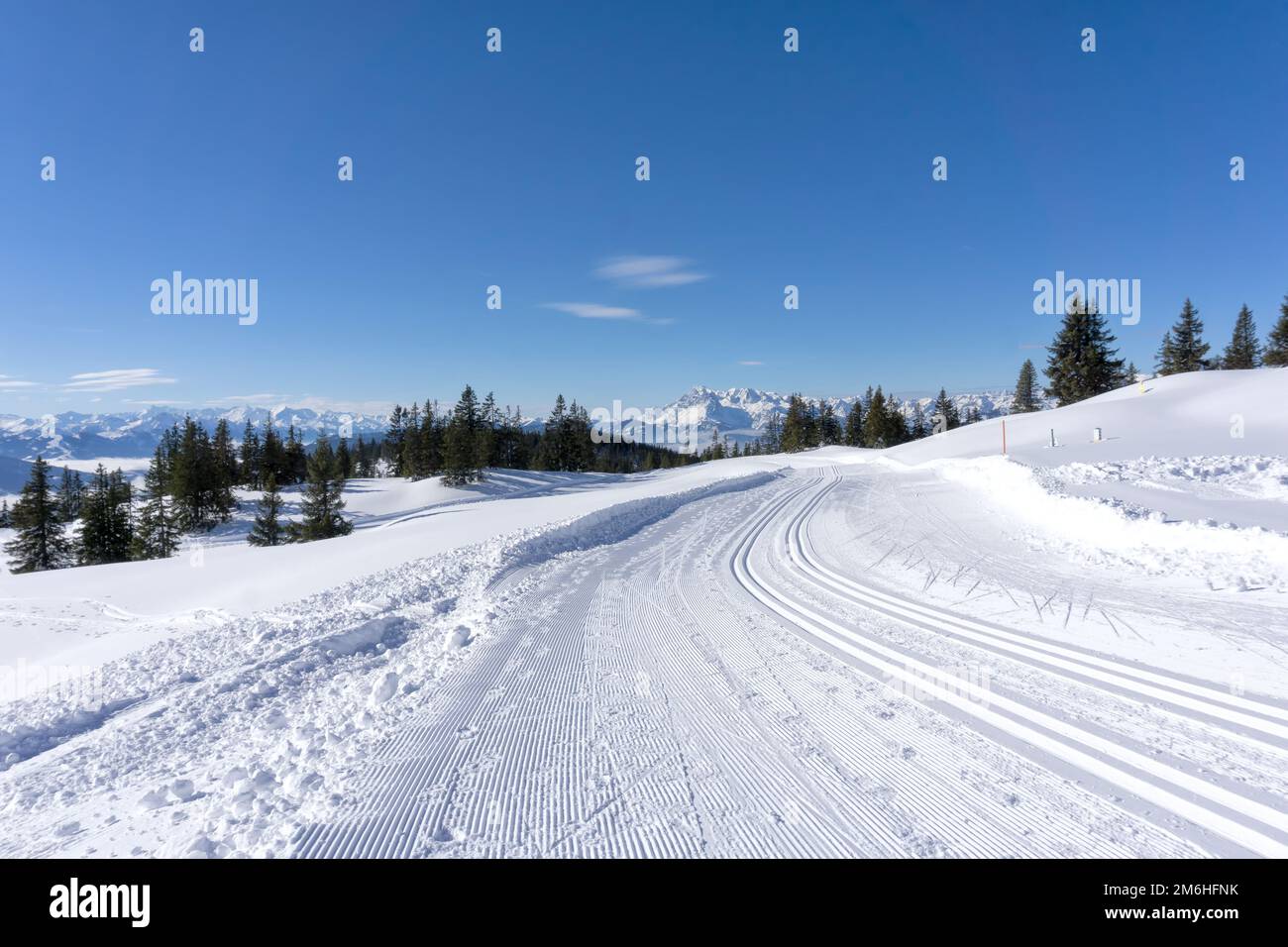 Winterberge, sonniger Tag in den Salzburger Alpen. Winterstraße mit gepflegten Skipisten. Stockfoto