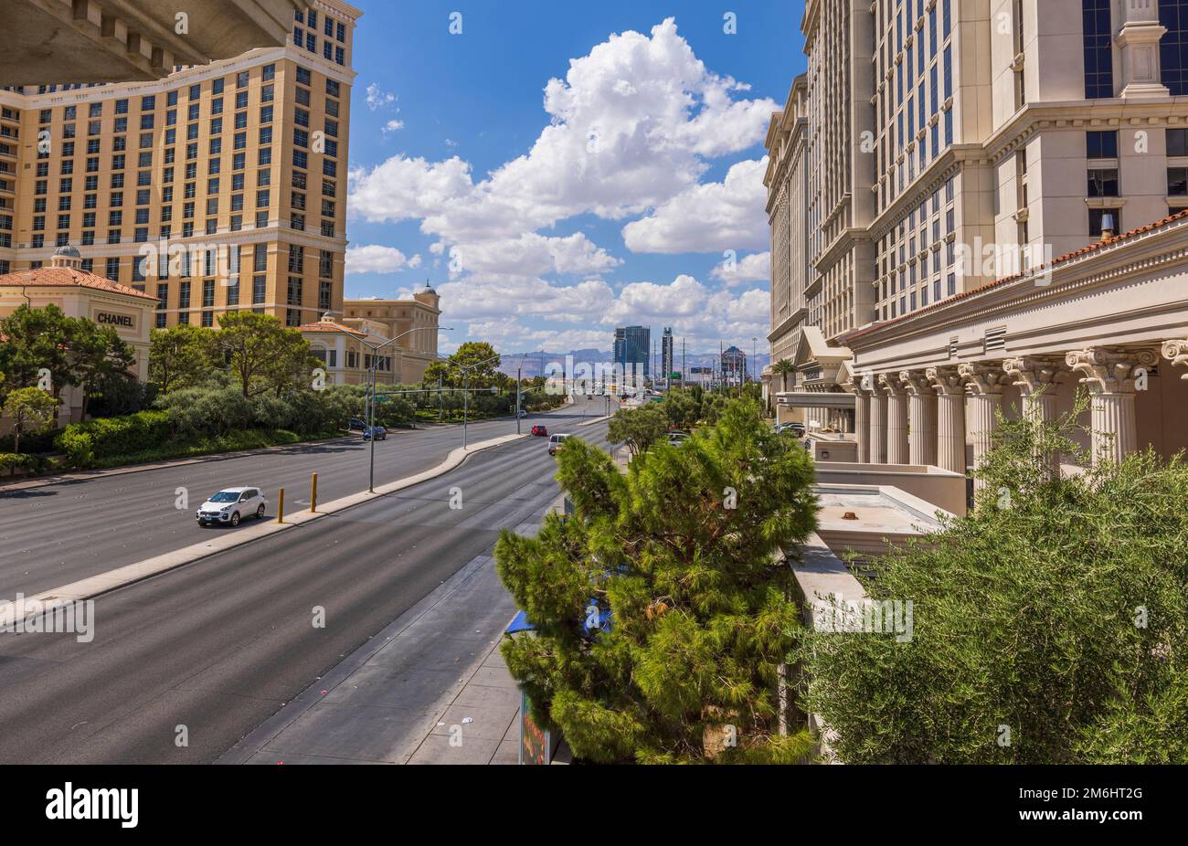 Wunderschöner Landschaftsblick auf die Strip Road zwischen zwei großen Hotels am blauen Himmel mit pudelweißen Wolken im Hintergrund. Las Vegas, Nevada, USA. Stockfoto