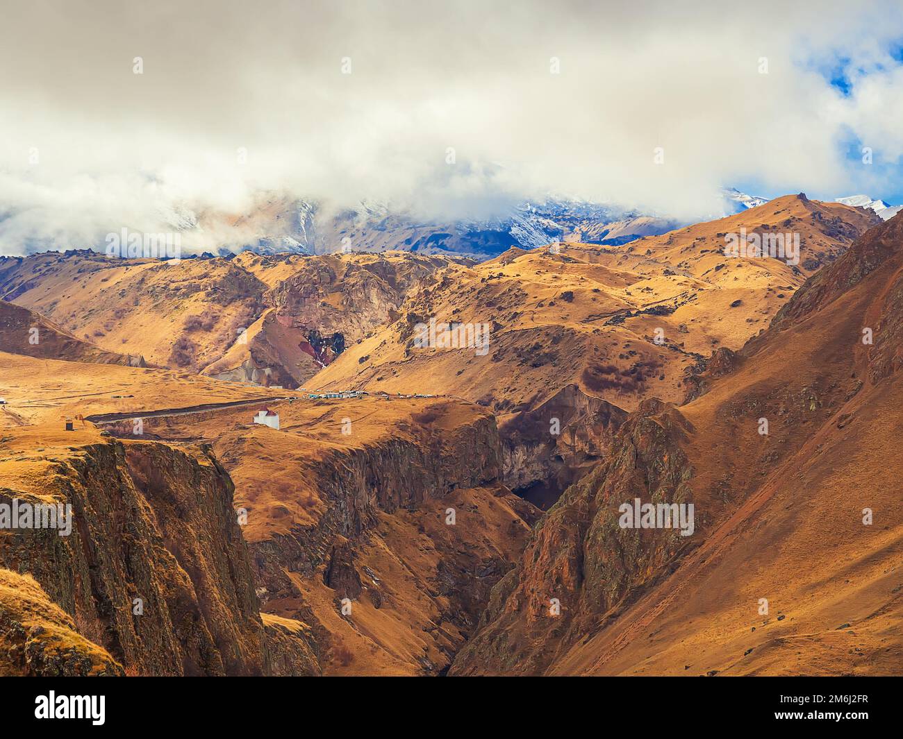Die Pracht des Herbstes des Bergtals im Bereich des ruhenden Vulkans Elbrus, versteckt hinter dicken weißen Wolken Stockfoto