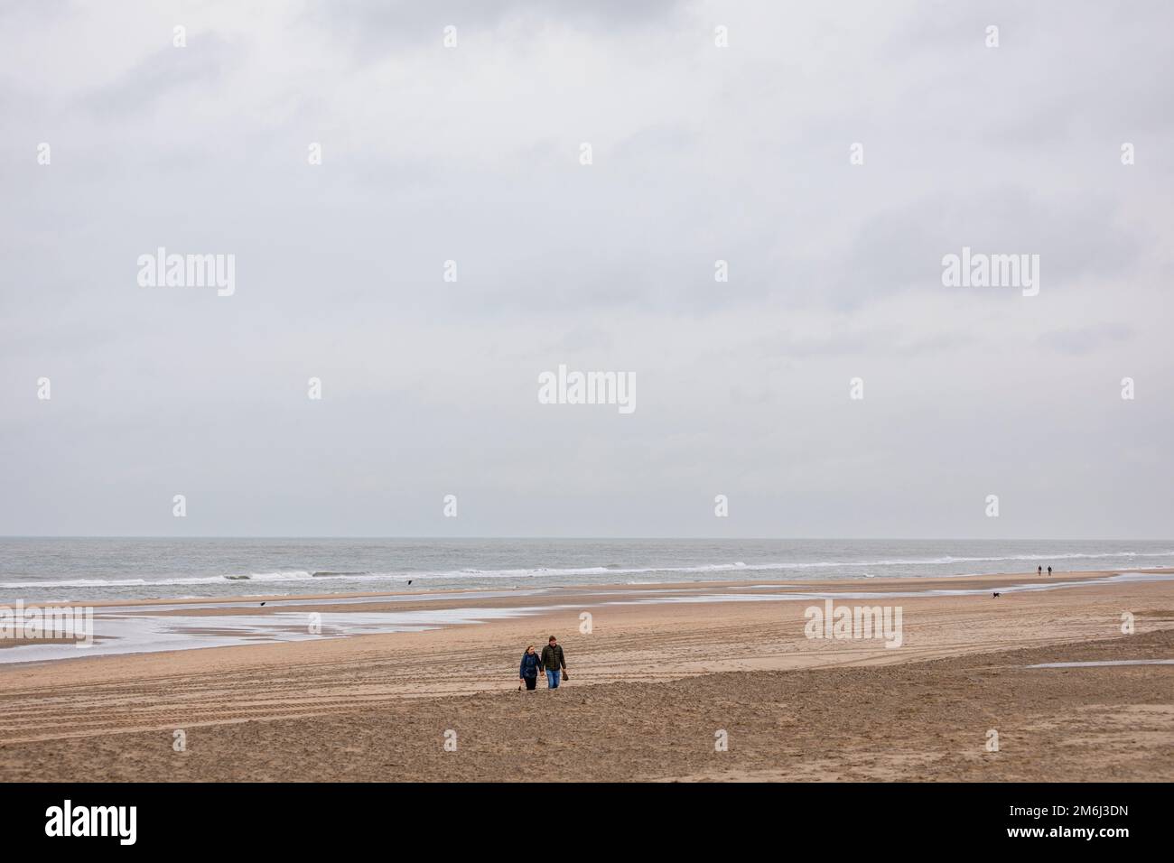 Zwei Personen, die am Strand in wnter in Noordwijk aan Zee, Niederlande, spazieren gehen Stockfoto