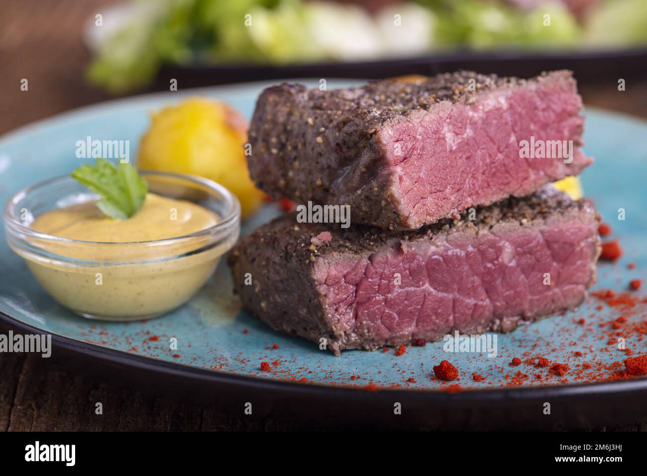 Steak-Scheiben auf blauem Teller Stockfoto