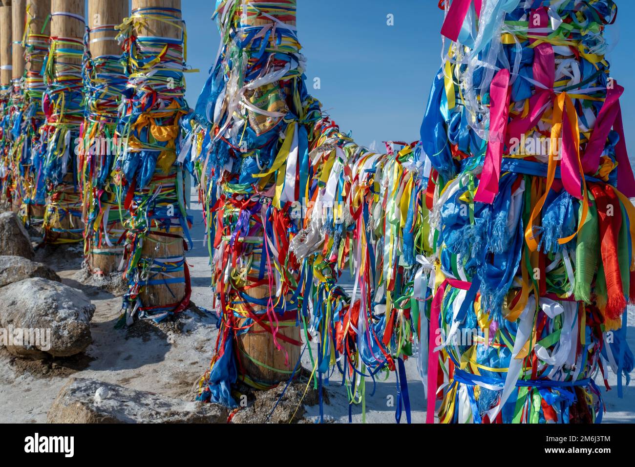 Rituelle Säulen aus Holz mit Farbbändern Stockfoto