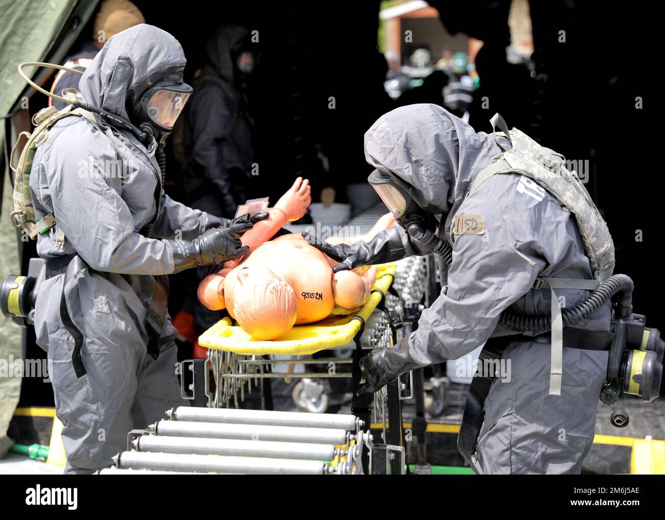 USA Soldaten der Army Reserve, die der 307. Chemical Company von Bell, Kalifornien, zugewiesen sind, bereiten sich darauf vor, einen Scheinpatienten während der Guardian Response 22 im Muscatatuck Urban Training Center, Indiana, 28. April 2022, durch eine Massenentzugslinie zu bringen. Guardian Response 22 ist eine Homeland Emergency Response Übung, die realistische Katastrophenreaktionsschulung bietet, um die Fähigkeiten der USA zu verbessern Soldaten Der Army Reserve. Stockfoto