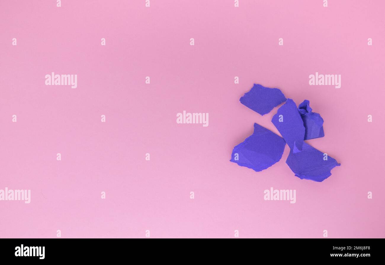 Ein Haufen Kugeln aus zerknittertem lila Papier auf pinkfarbenem Hintergrund. Das Konzept des Minimalismus, eine Kopie des linken Raumes Stockfoto