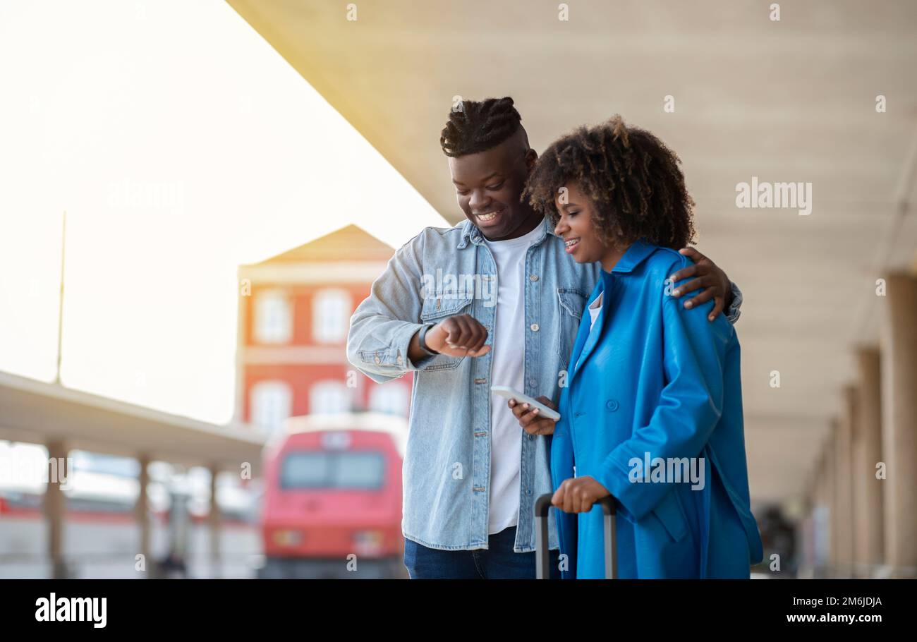 Portrait Von Happy Black Pair, Das Am Bahnhof Auf Den Zug Wartet Stockfoto