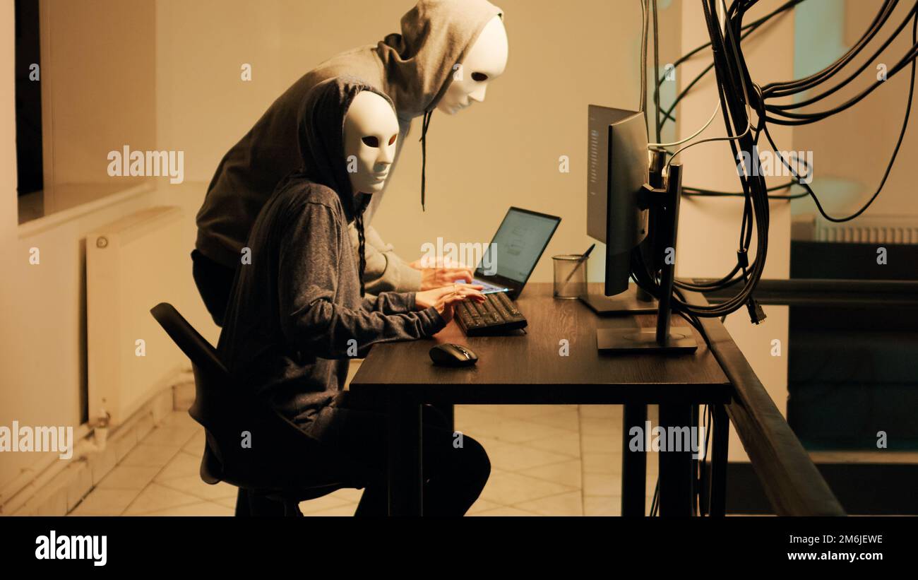Hacker mit weißen Masken hacken das Netzwerk, um Passwörter direkt aus