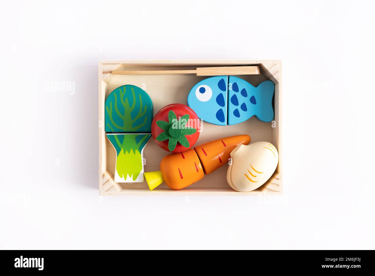 Lebensmittelspielzeuge auf weißem Hintergrund. Kreatives Holzdesign, vegetarisches Gemüse und Fisch. Entwicklung des Kindes. Kinder spielen. Stockfoto