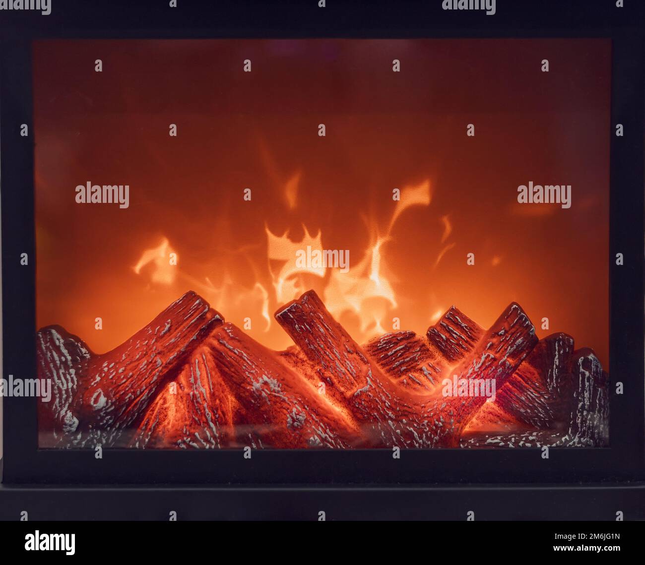 Kamin mit hellen Flammen. Künstlicher dekorativer Kamin mit Feuerimitat. Moderne Technologie für den Heimkomfort. Volle Schublade Stockfoto
