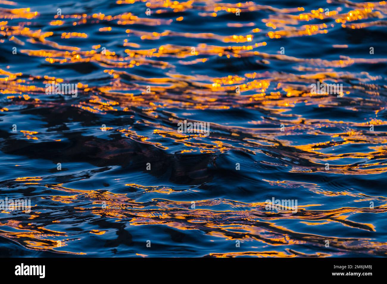 Spiegelung der orangen und tiefblauen Farbe der Wellen des Flusses Stockfoto