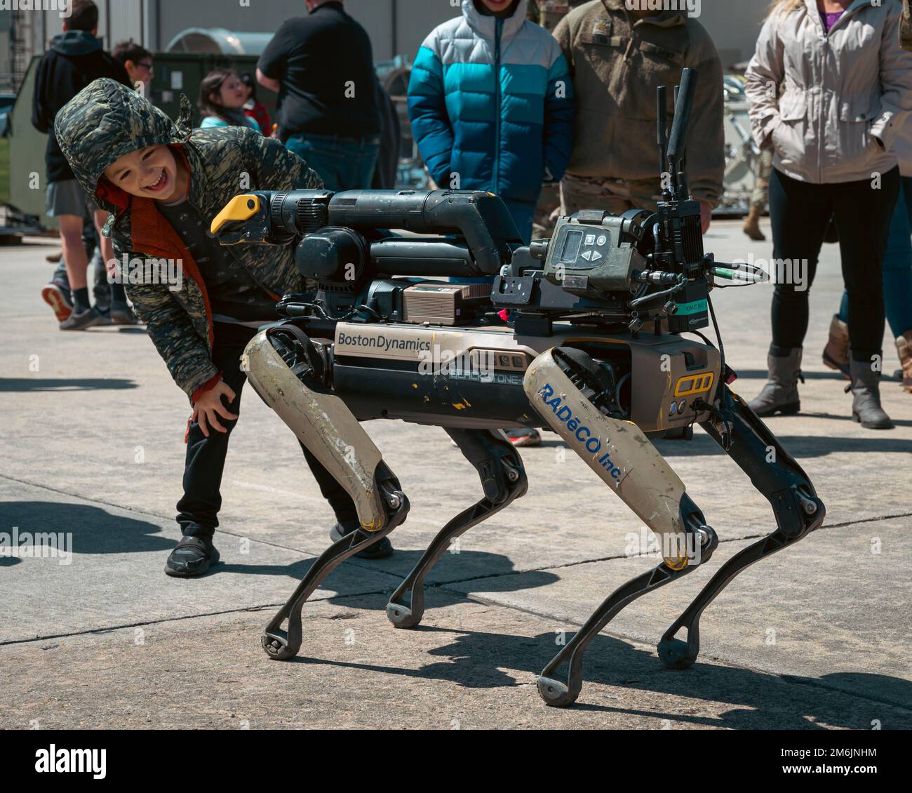 Ein militärisches Kind interagiert mit einem Bostoner Dynamics Spot-Roboter, ausgestattet mit Hazmat Response Gear auf der Joint Base McGuire-Dix-Lakehurst, N.J., 28. April 2022. Joint Base MDL feierte den Monat des Militärkindes mit statischen Flugzeugausstellungen und Aktivitäten. Stockfoto