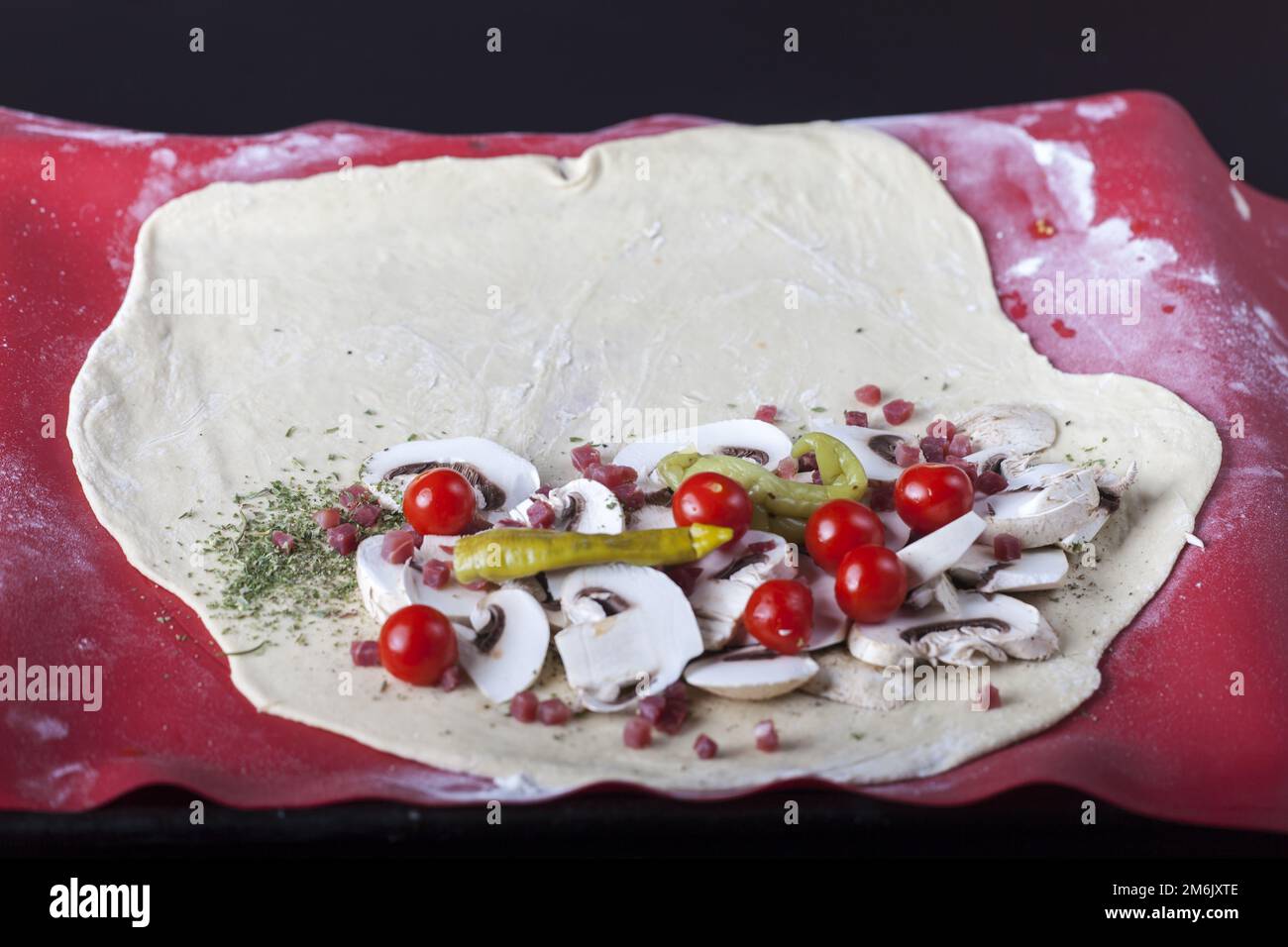 Rohe Pizza Calzone auf einem Silikonbackblech Stockfoto