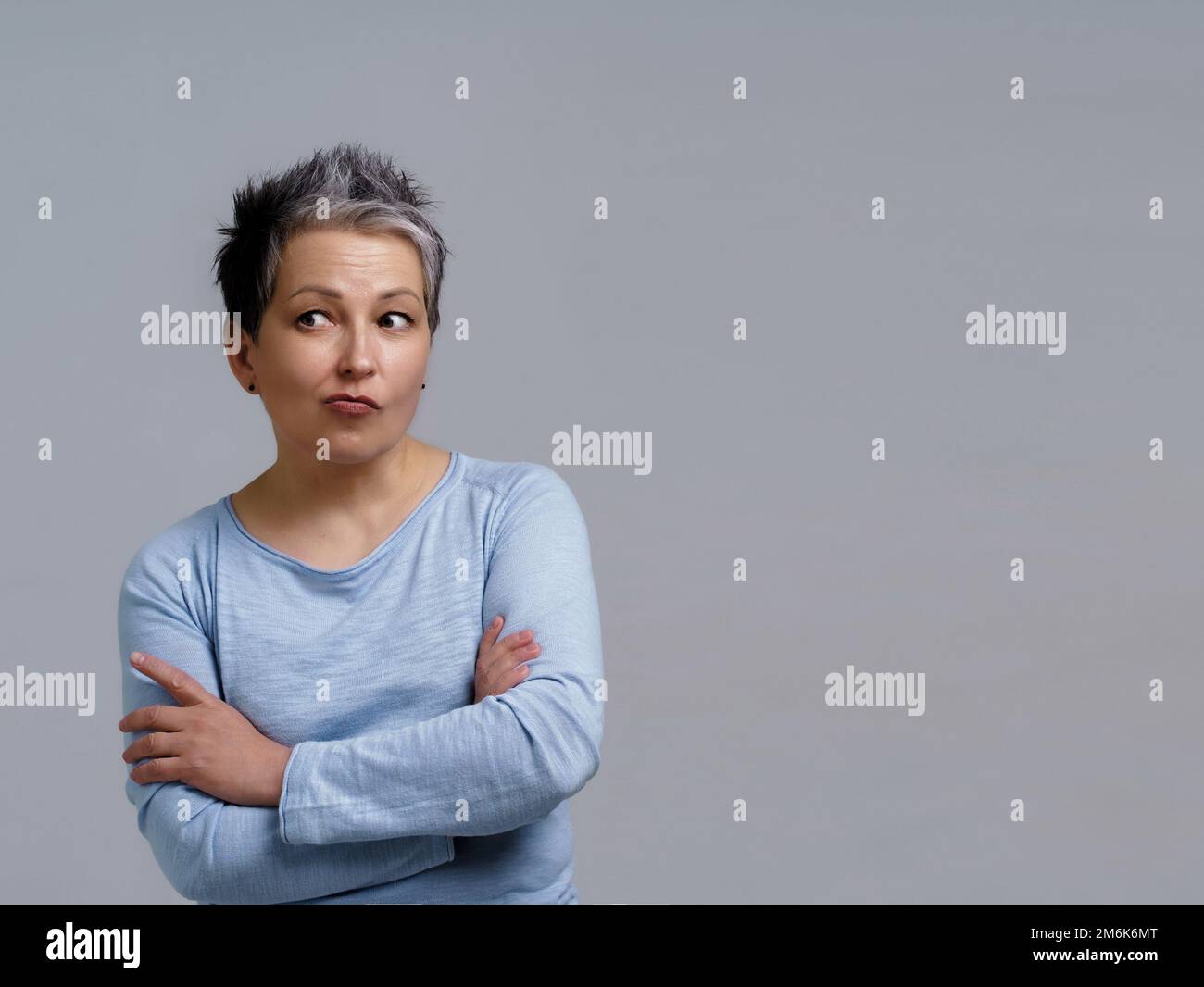 Porträt einer nachdenklichen, durchdachten, reifen Geschäftsfrau mit grauem Haar in 50s mit gefalteten Händen und Kopierbereich auf der rechten Seite für die Produktion Stockfoto