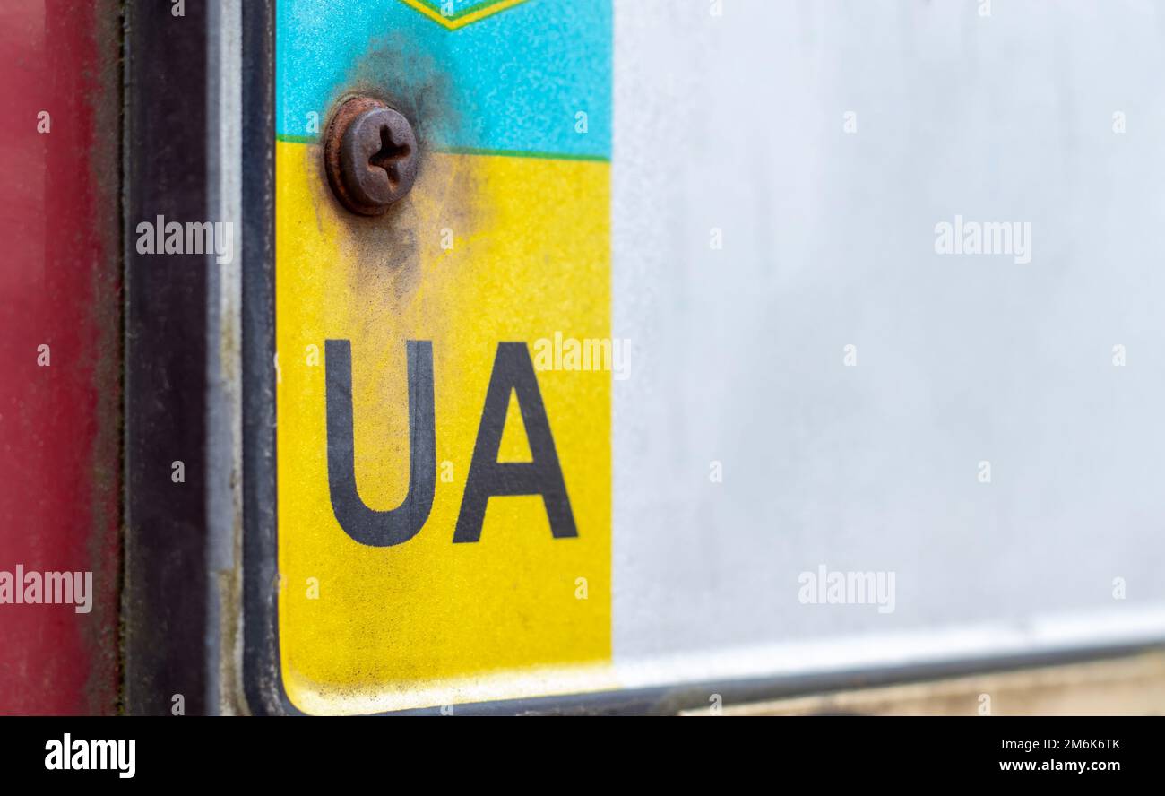 Ein Teil des ukrainischen Nummernschilds auf der Nahaufnahme der Stoßstange. Das Symbol der Nationalität auf dem Hintergrund der Farben des Fla Stockfoto