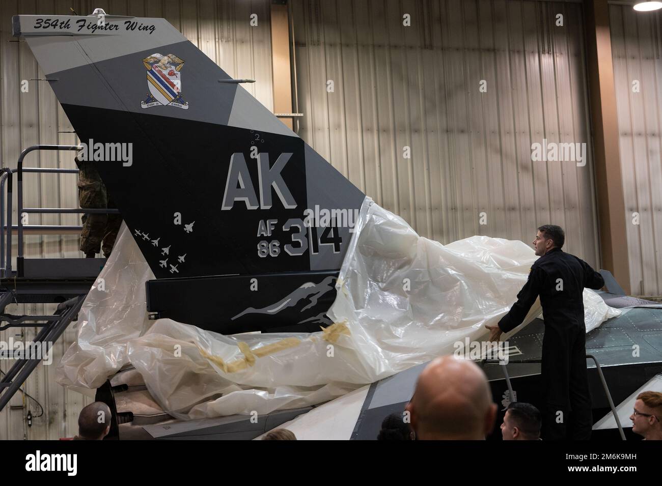 USA Air Force Oberst Thomas Wolfe, Vizekommandeur des 354. Kampfflugzeugs, enthüllt den neu bemalten Schwanz auf dem Flaggschiff F-16 Fighting Falcon während einer Zeremonie auf dem Luftwaffenstützpunkt Eielson, Alaska, am 29. April 2022. Der Heckblitz zeigt Bilder, die die Geschichte und Lage der Basis im Inneren Alaskas würdigen, mit Bergen, einem historischen Flügellogo und verschiedenen Jet-Silhouetten. Stockfoto