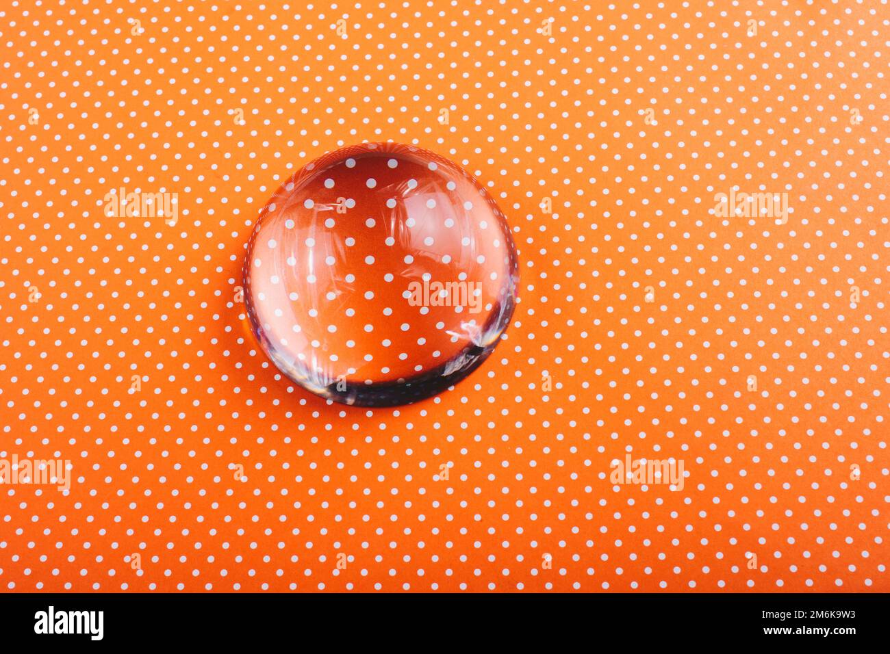 Eine halbe Glaskugel auf einem gepunkteten Papier Stockfoto