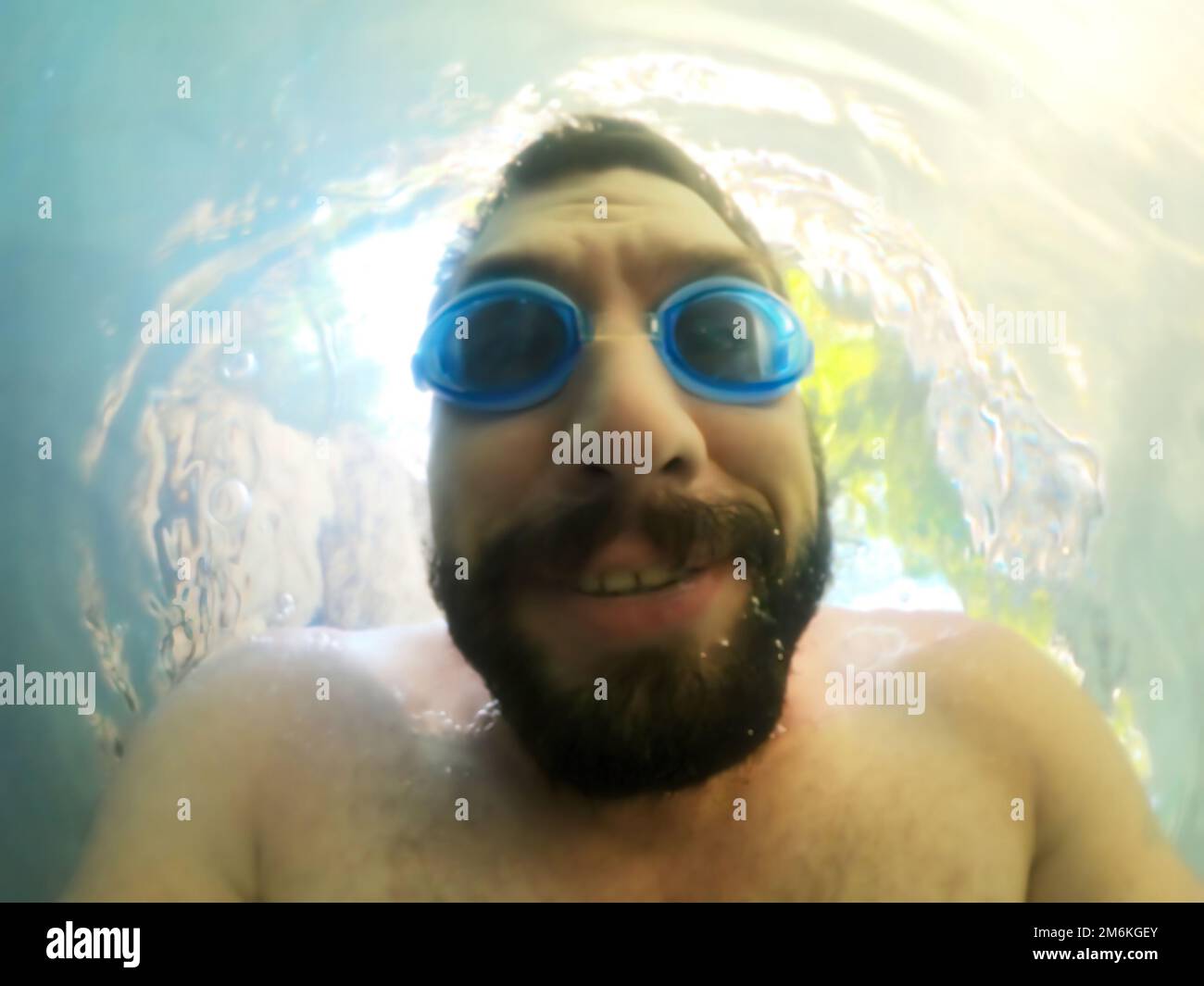 Porträt eines bärtigen Mannes mit Schwimmbrille unter Wasser. Im Sommer aktive Erholung und Tauchen. Stockfoto