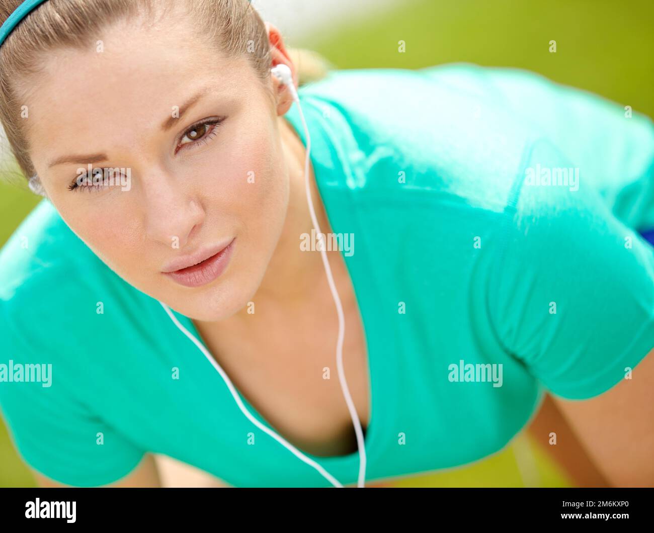 Mach diesen Lauf zu einem unvergesslichen Erlebnis. Nahaufnahme einer Joggingfrau, die sich nach vorne lehnt und in die Kamera schaut. Stockfoto